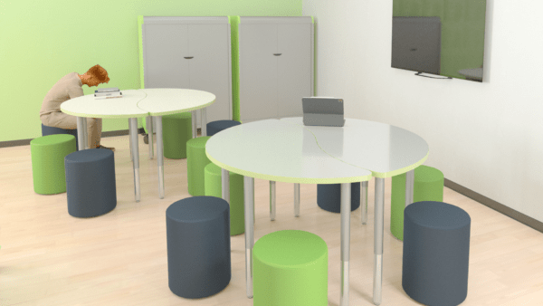Four Ogee Cirrus tables paired to form two circular seating areas. Round soft seating ottomans for seating around the two tables in an alternating green and grey patter, In a classroom setting.
